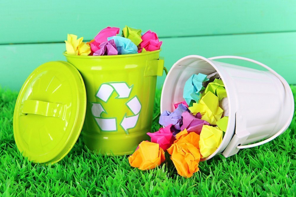 Image shows a recycling bin full of colourful paper.