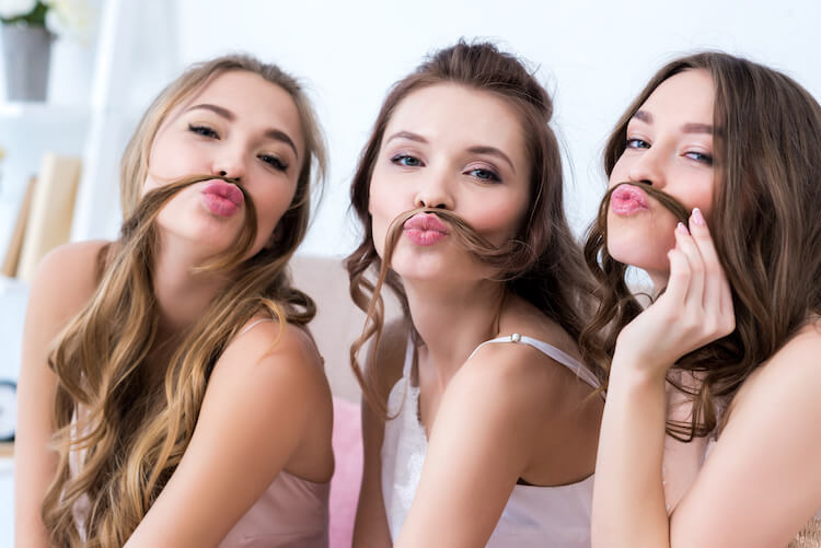 Affirmations for friends | Three young women being silly together by using their long hair like moustaches.
