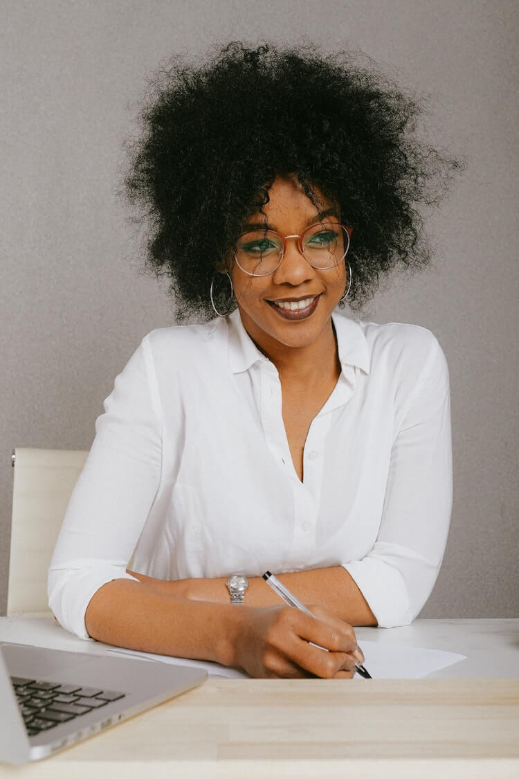 Corporate headshot photography of a woman writing.