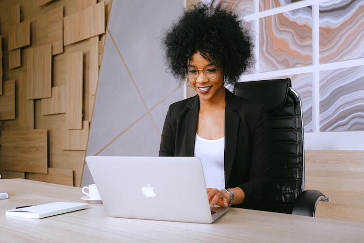 Professional female headshot of a woman sitting at her desk typing.